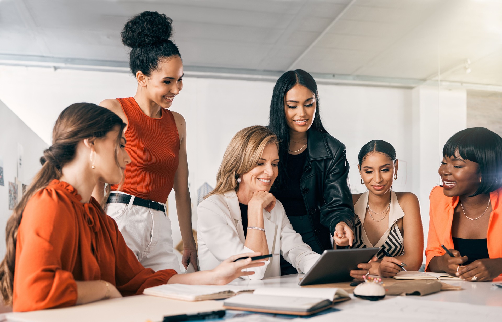 Shot of a group of businesswomen using a digital tablet together at work